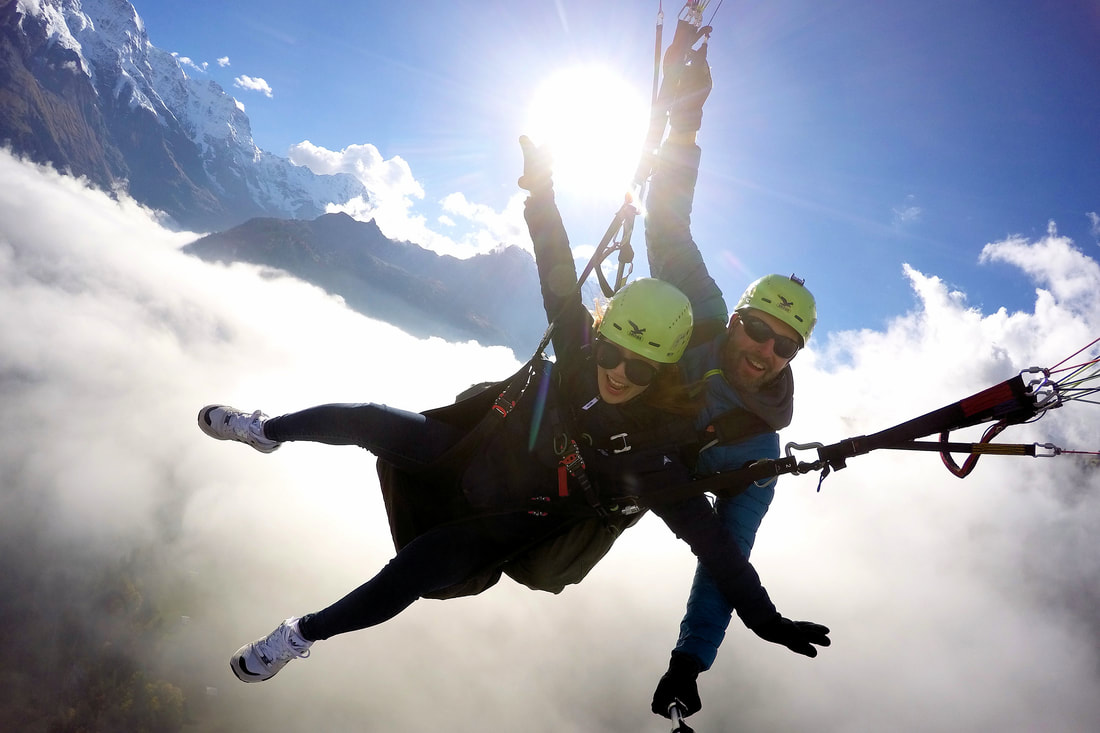 Deux personnes s'amusant pendant leur vol en Parapente biplace à Interlaken depuis Schynige Platte au coucher du soleil avec AlpinAir Paragliding Interlaken.