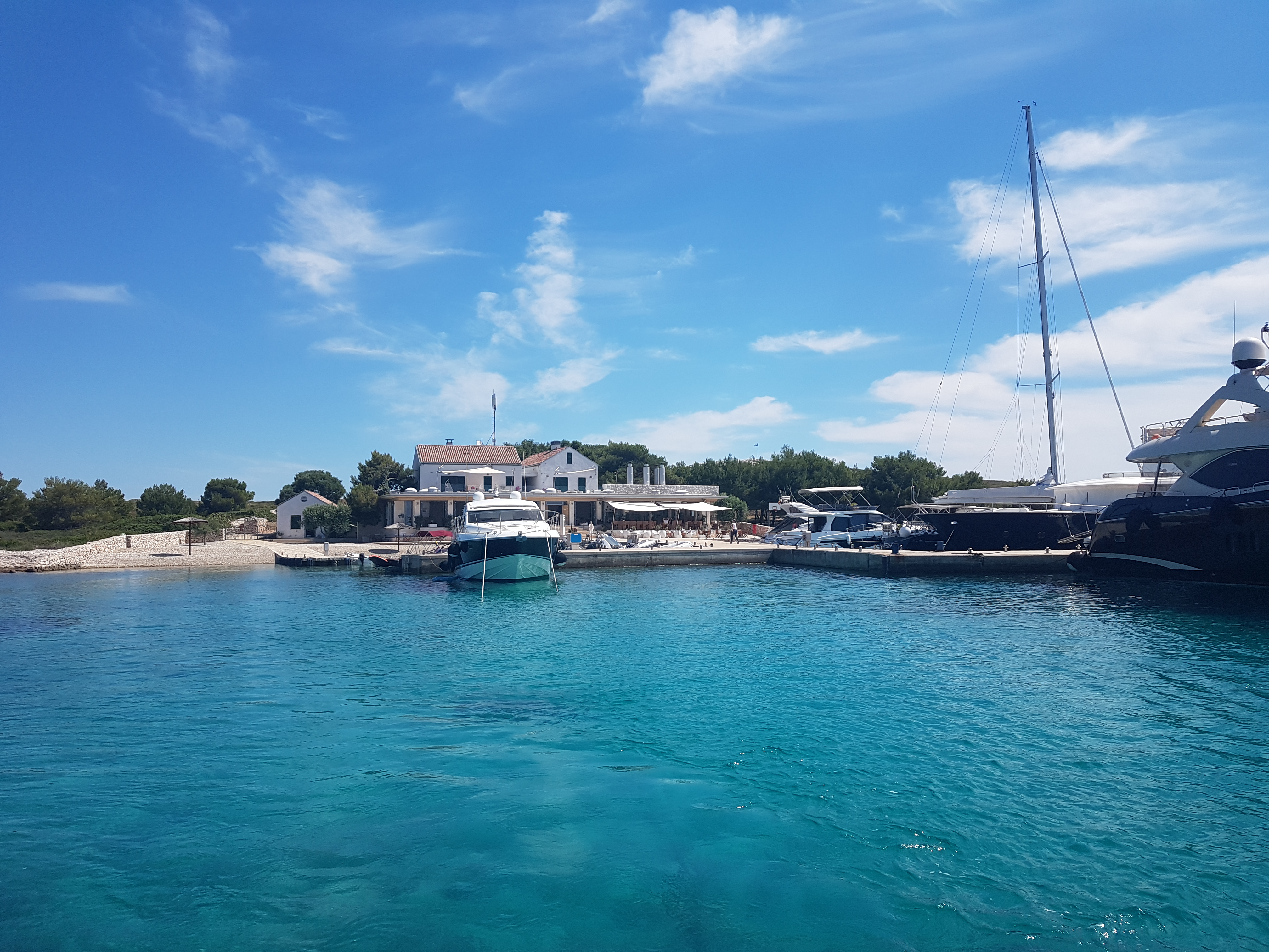 Boat trip to a bay in the Kornati National Park Several yachts are docked in a tranquil, turquoise bay during a boat trip to the Kornati National Park with lunch and drink from Avalon Yachting Šibenik.