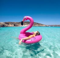 Una chica disfrutando en el mar durante un viaje en barco privado a las islas Comino y Gozo con snorkel con Outdoor Explorers.