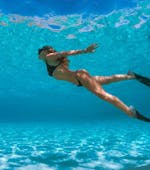 Eine Frau schwimmt während der RIB-Bootstour nach Cala Coticcio (Tahiti) mit Schnorcheln von Scuba Revolution Cannigione.