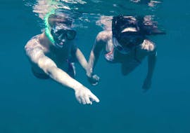 Deux personnes faisant du snorkeling pendant la balade en bateau semi-rigide sur l'île de Caprera avec snorkeling avec Scuba Revolution Cannigione.