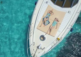 Due persone si rilassano al sole durante la Gita in barca privata alla spiaggia la Pelosa con Pranzo con My Azimut Dream Stintino.