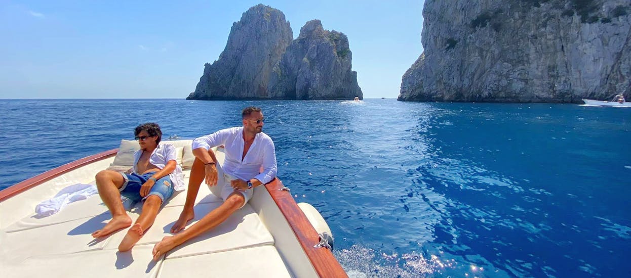 Dos hombres toman el sol en el barco de HP Travel Capri durante la excursión en barco por Capri con Apéritif "La Dolce Vita".