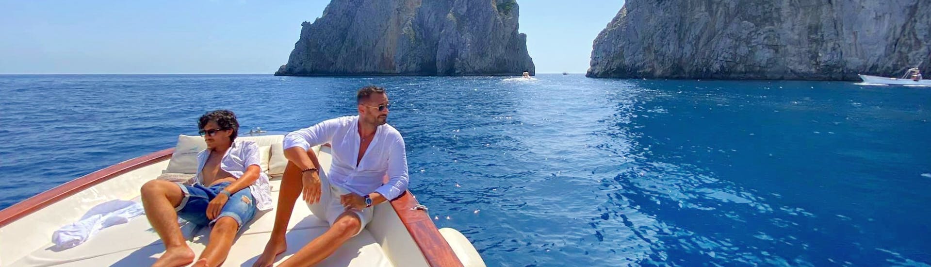 Deux hommes prennent un bain de soleil sur le bateau de HP Travel Capri pendant la Balade en bateau autour de Capri avec Apéritif "La Dolce Vita".