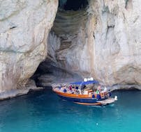 La barca di HP Travel Capri davanti ad una grotta durante il Giro in barca intorno a Capri con aperitivo.