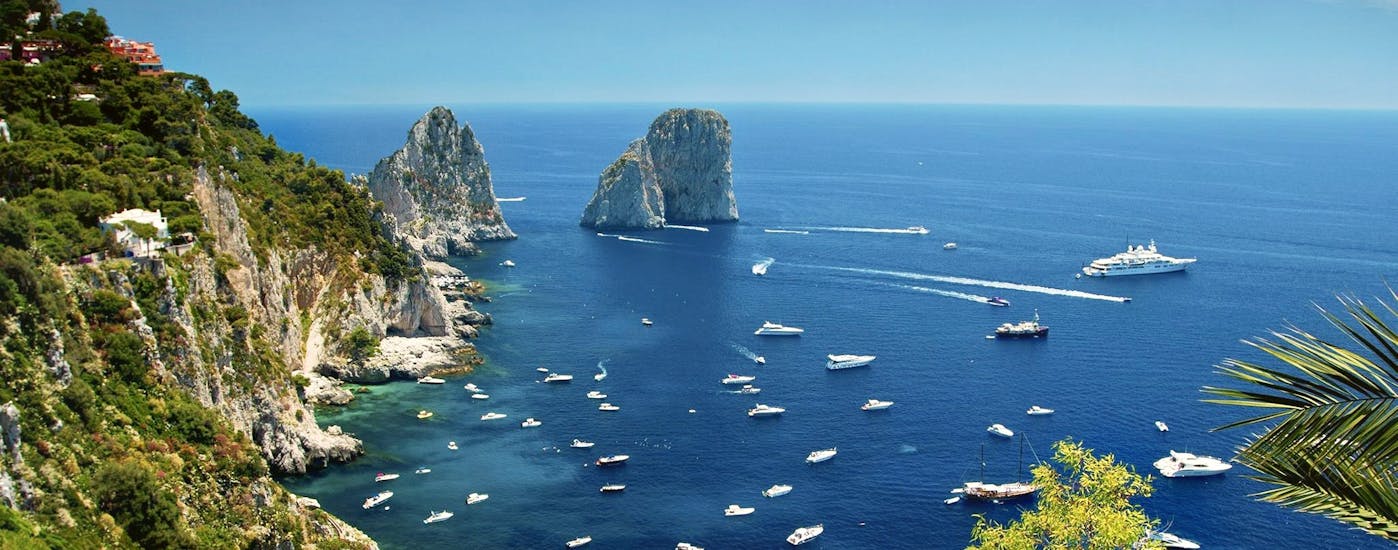 Panoramic view of the Faraglioni seen during the Boat Trip around Capri with Guided Tour of the Island with HP Travel.