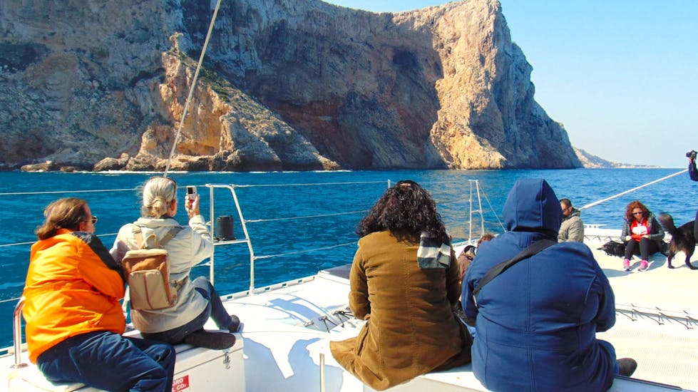 Un grupo de participantes en un día soleado disfrutando de la Costa del Sol en un catamarán de vela ecológico durante un viaje en catamaran con Mundo Marino Costa del Sol.