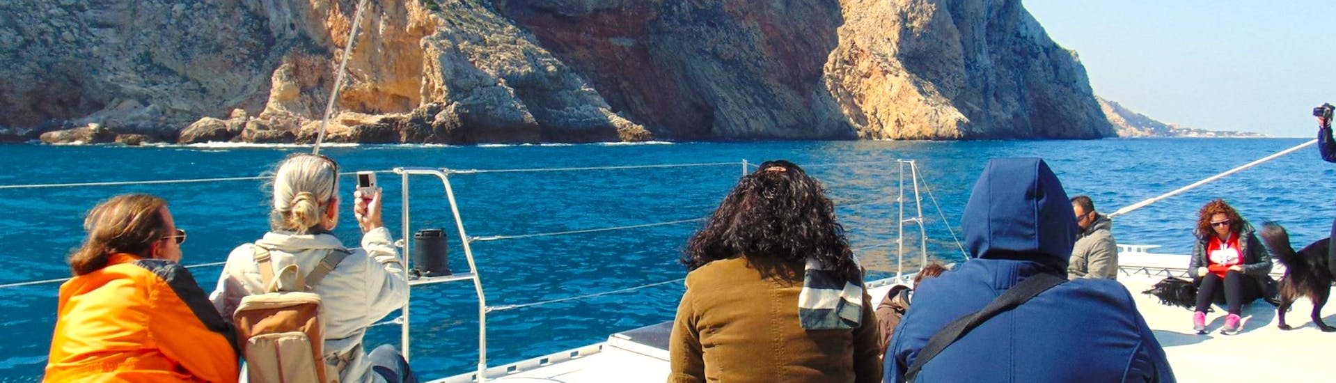 Eine Gruppe von Teilnehmern genießt an einem sonnigen Tag die Costa del Sol auf einem Öko-Segelkatamaran bei einer Segelboottour mit Mundo Marino Costa del Sol.