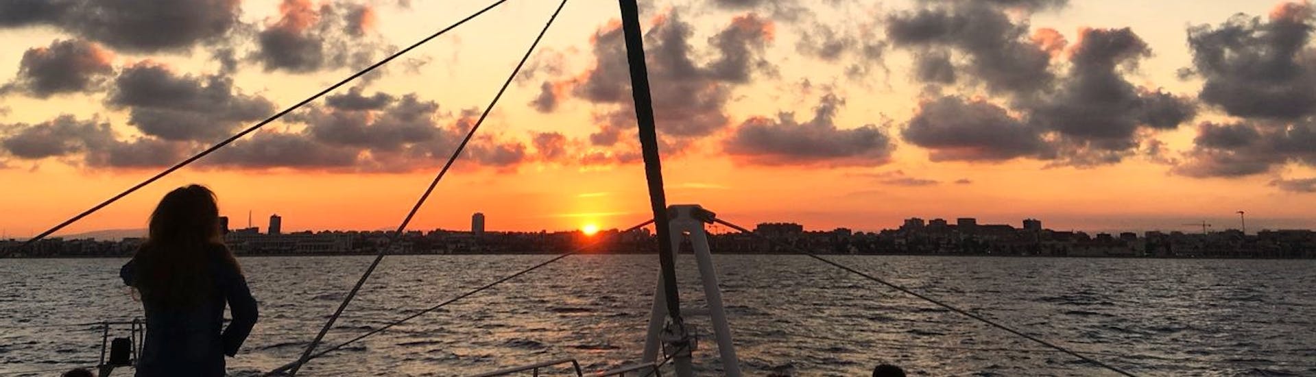 Preciosa puesta de sol sobre la bahía de Málaga, con tonalidades rojas y naranjas durante un paseo en catamaran con Mundo Marino Costa del Sol.