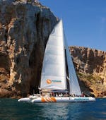 Een elegante eco-zeilcatamaran met deelnemers die plezier hebben tijdens een zeilboottocht langs de baai van Malaga met Mundo Marino Costa del Sol.
