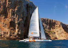 Ein eleganter Öko-Segelkatamaran mit Teilnehmern, die sich bei einem Segeltörn entlang der Bucht von Málaga mit Mundo Marino Costa del Sol vergnügen.