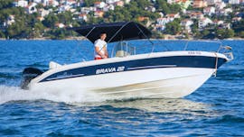 Mann fährt das Boot, das beim Bootsverleih in Seget Donji (bis zu 8 Personen) mit Space Fun Seget Vranjica ausgeliehen werden kann über die Gewässer in Kroatien.