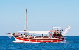 Ein Gruppe von Leuten sitzt bei der Bootstour von Poreč nach Rovinj & Vrsar mit BBQ von Santa Maria Boat Cruises im altmodischen Vintage-Boot.