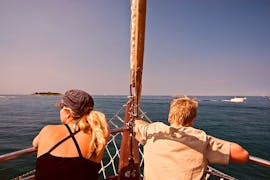 Twee personen die een zeiltocht bij zonsondergang maken vanuit Poreč met dolfijnen kijken met Santa Maria Boat Cruises Poreč.