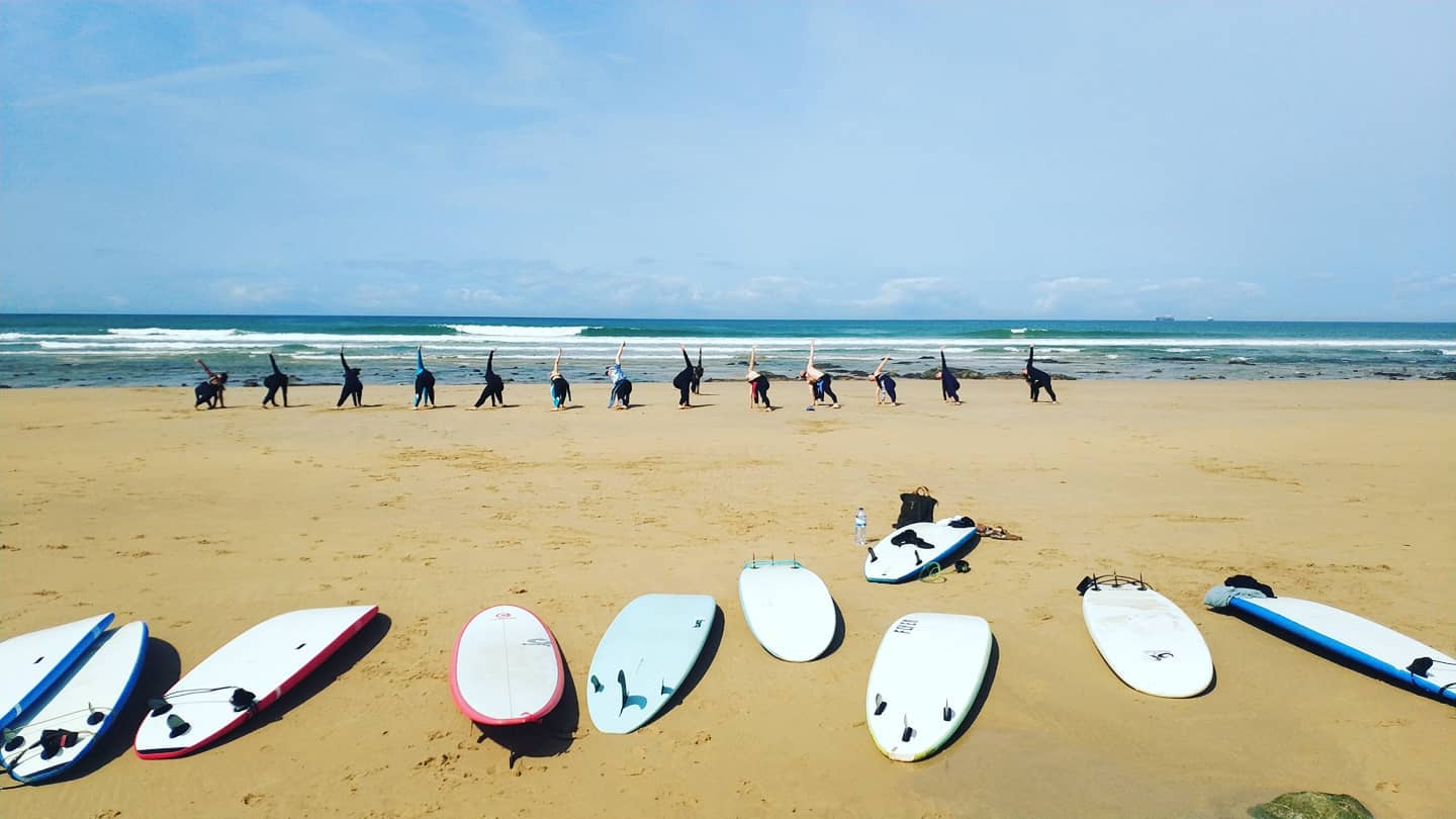 A group of people warming up during an intensive surf lessons in Vila Nova de Milfontes with Alentejo Surf School.