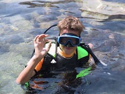 Un garçon s'essaye à la plongée pendant le Baptême de plongée dans le parc marin d'Isola Bella avec Nike Diving Centre Taormina.