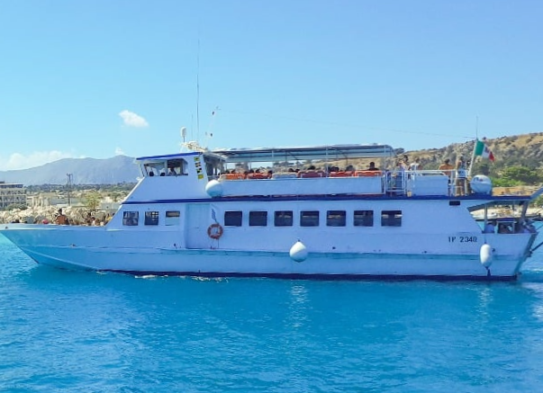 Photo of our motorboat as it navigates the waters of the Egadi archipelago during a boat trip from San Vito Lo Capo to Favignana and Levanzo with Egadi Navigazione.
