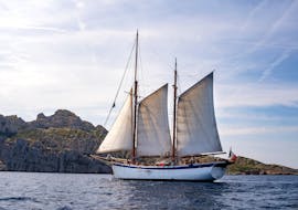 Notre bateau La Goélette Alliance devant les falaises des calanques lors de la Balade privée en voilier aux calanques de Marseille ou aux îles du Frioul.