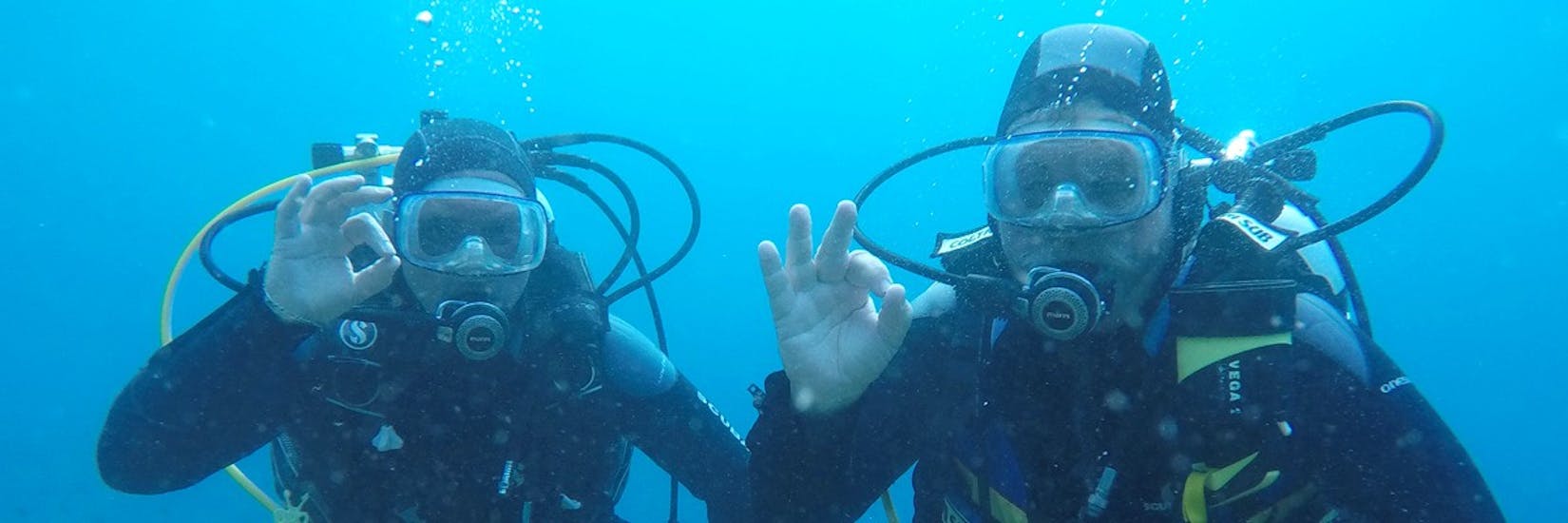Two divers showing the ok sign into the camera during the Guided Dives in Krk for Certified Divers with Diver Krk.