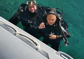 Ein Kind und ein Erwachsener lächeln in die Kamera vom Wasser aus während des SSI Open Water Diver Tauchkurs in Krk für Anfänger mit Diver Krk.