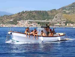Nuestro barco fotografiado durante una parada para nadar y hacer esnórquel en una excursión en barco desde Giardini Naxos, por la costa de Taormina, con Enjoy Sicily.