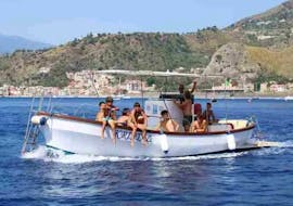Nuestro barco fotografiado durante una parada para nadar y hacer esnórquel en una excursión en barco desde Giardini Naxos, por la costa de Taormina, con Enjoy Sicily.