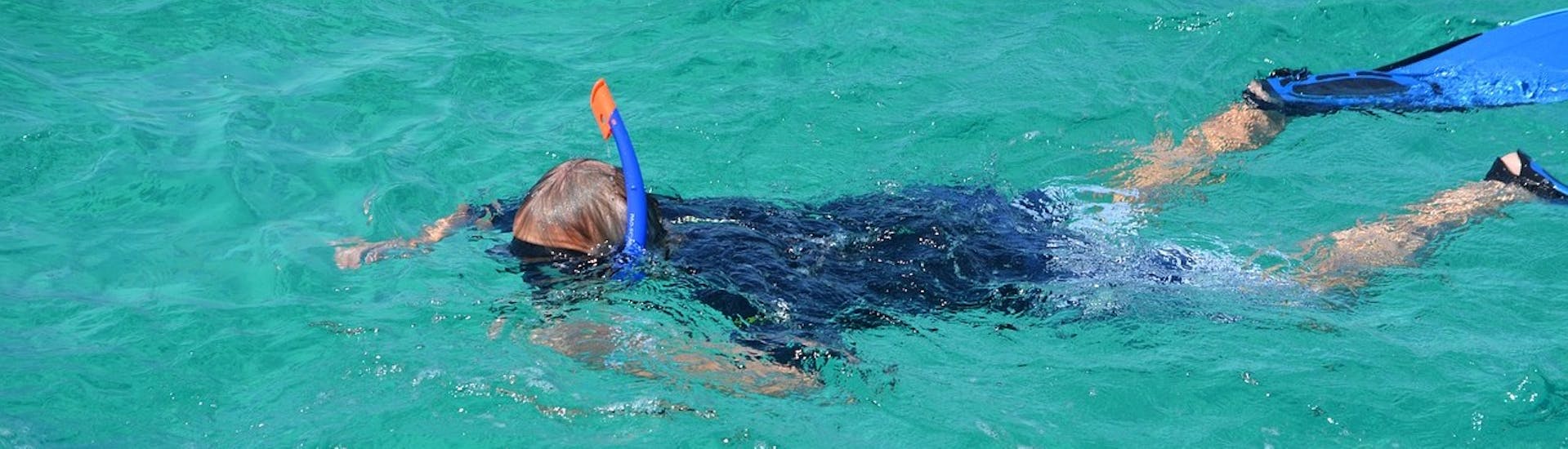 A child enjoys snorkeling during a boat trip from Giardini Naxos to Isola Bella with Enjoy Sicily.