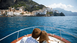 Una coppia si gode il nostro giro in barca privato da Giardini Naxos lungo la costa di Taormina con Enjoy Sicily.