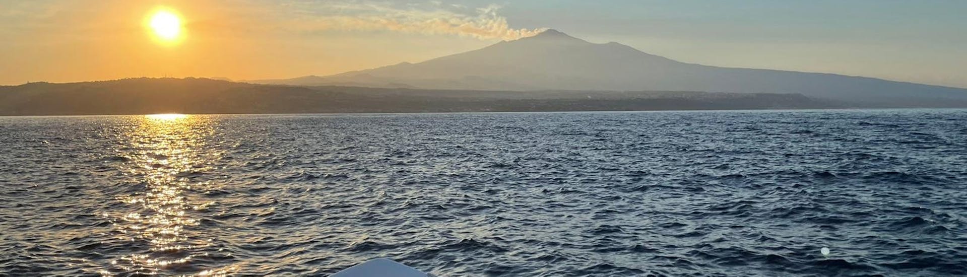 Il tramonto sull'Etna visto dalla barca di Navigando per Trezza durante la Gita in barca da Aci Trezza con aperitivo al tramonto.