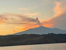 View of Etna from the sea at sunset during the boat trip from Aci Trezza with Aperitivo with Navigando per Trezza.