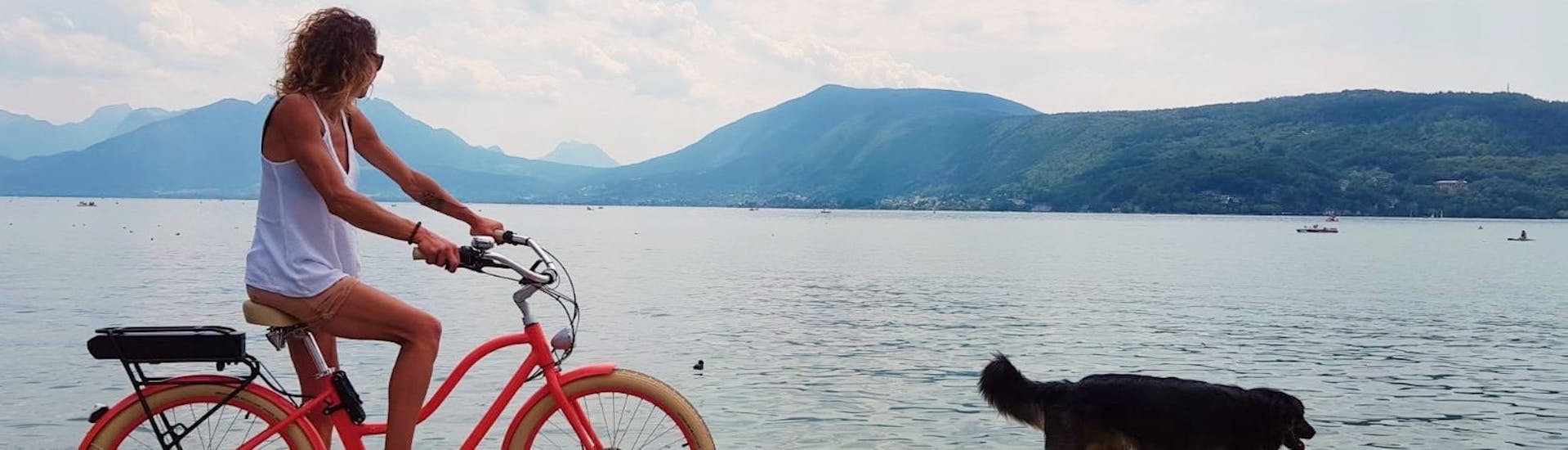A woman doing a City Bike Hire around Lake Annecy with Cayoti.