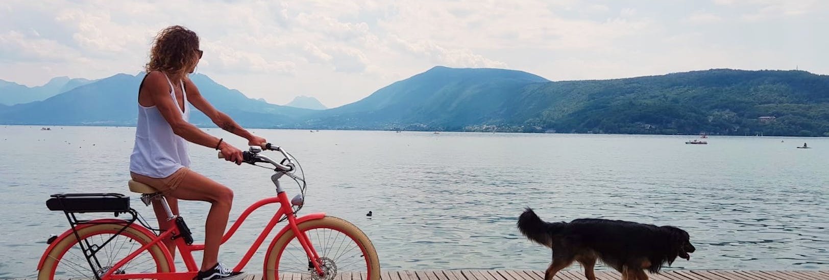 A woman and her dog do a E-Bike Hire around Lake Annecy with Cayoti Veyrier-du-Lac