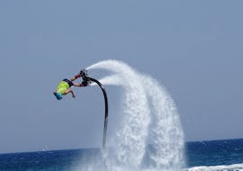 Een man oefent flyboarden op het Psalidi strand met Flyboard Watersports Kos.