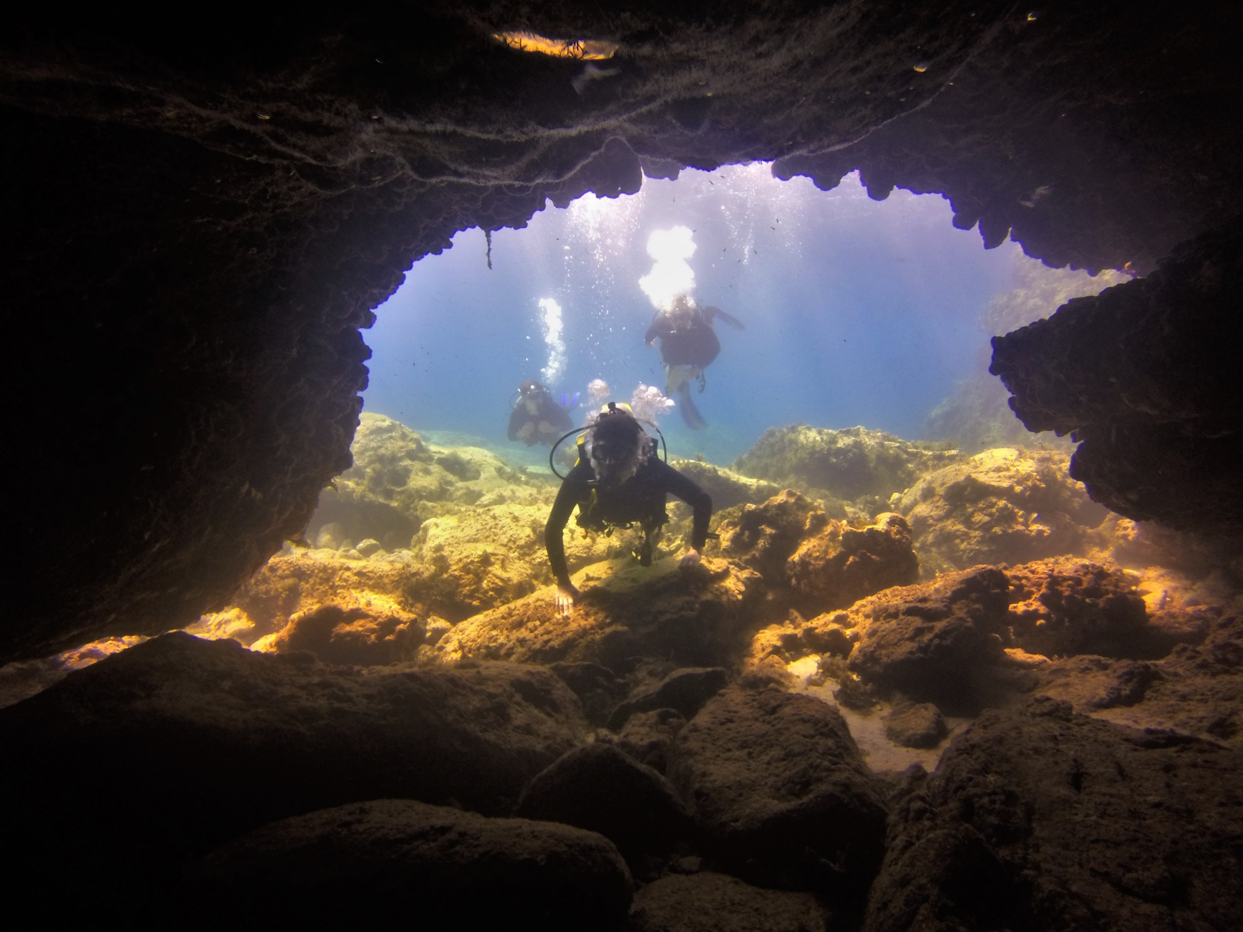 Divers dive into a cave and discover marine life on the PADI Advanced Open Water Diver course in Penera for certified divers with Taba Diving Cyprus.