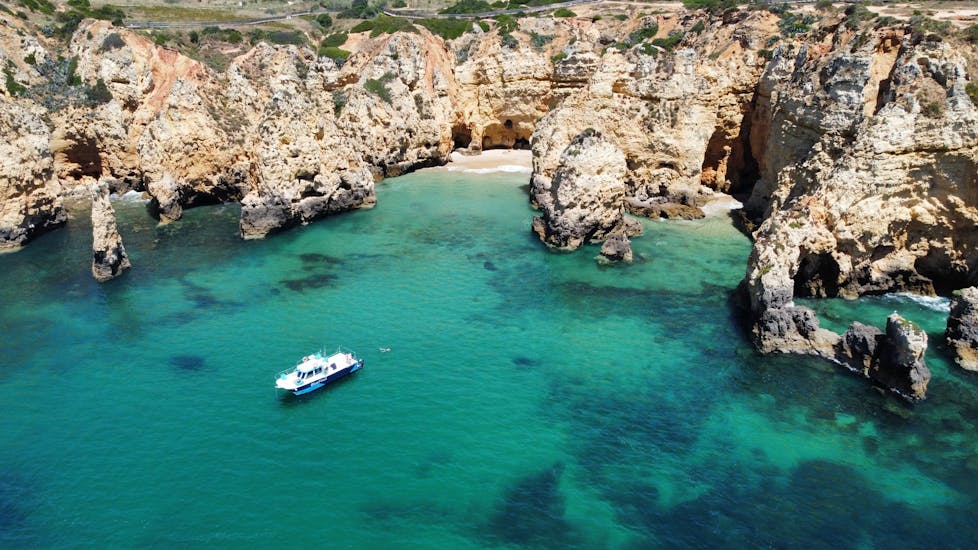 The boat of BlueFleet Lagos in a bay during the Boat Trip along the Coast to Ponta da Piedade with Swimming.