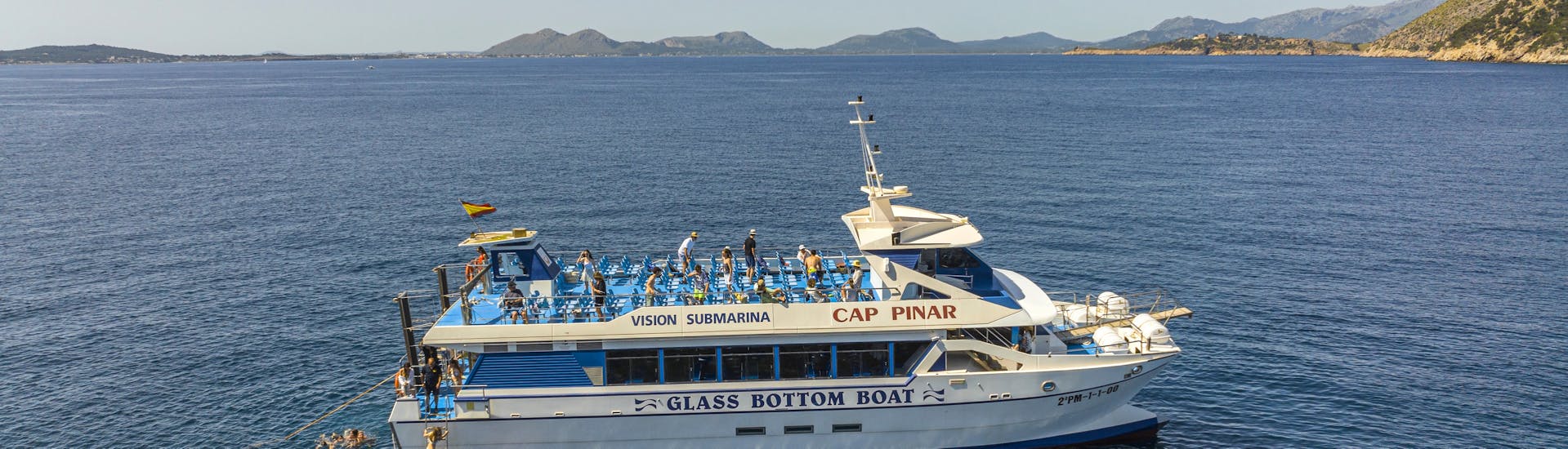 Menschen genießen die Zeit auf dem Boot während der Katamaran-Tour durch die Bucht von Pollença mit Lanchas La Gaviota Pollença.