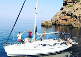 Due ragazzi salutano dalla barca durante la Gita in barca a vela privata di un'intera giornata a Palma con Vela Mayorca Palma.