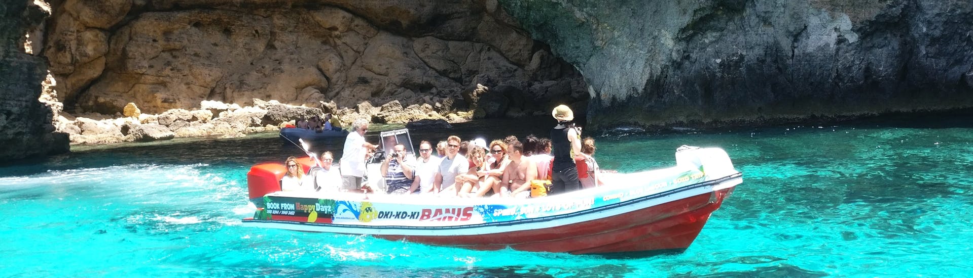 Die Passagiere genießen die Sonne während der Speeboat-Tour zu den Höhlen von Comino ab St. Julian's.