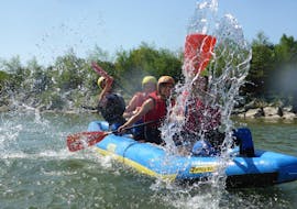 Freunde planschen mit Wasser auf dem Canadier-Rafting auf der Iller im Allgäu bei einer Tagestour mit Spirits of Nature Allgäu.