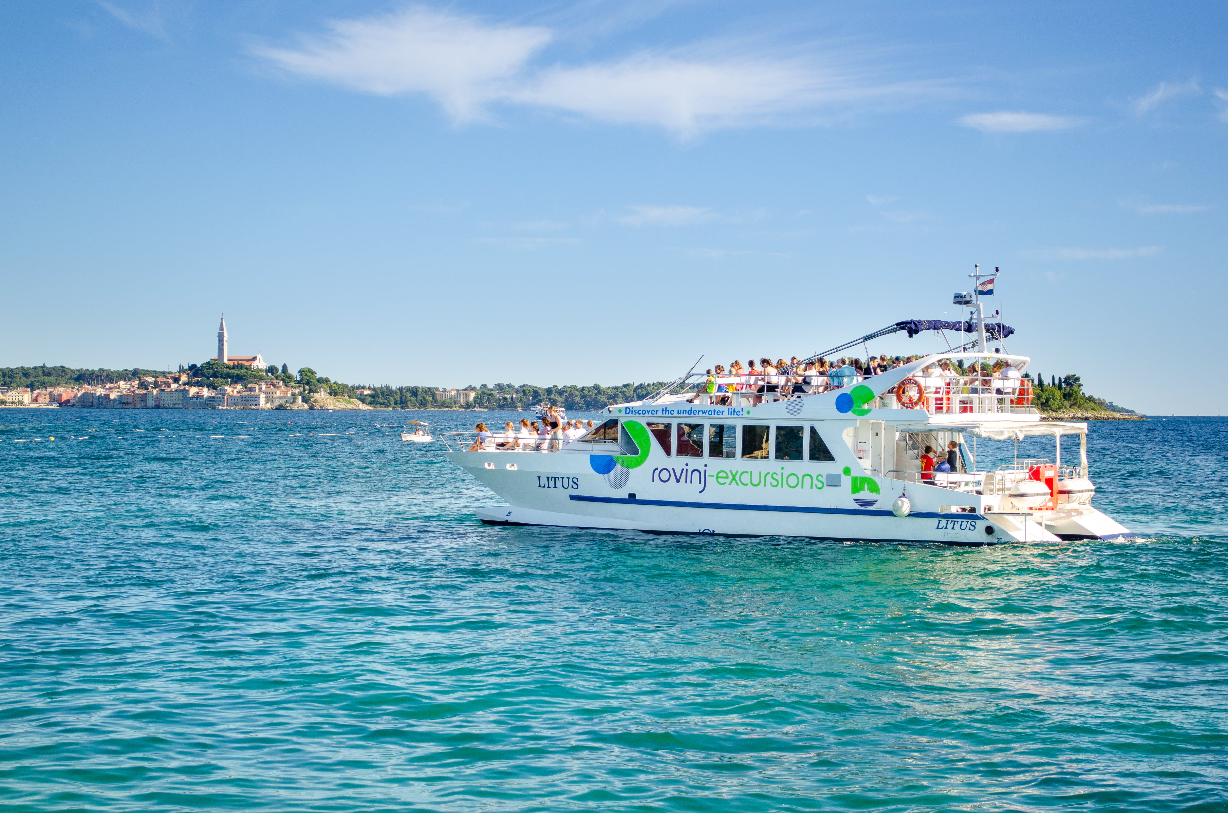 Le catamaran LITUS dans l'eau cristalline de l'Istrie pendant la demi-journée de balade en catamaran à Vrsar et au fjord de Lim avec Rovinj Excursions.