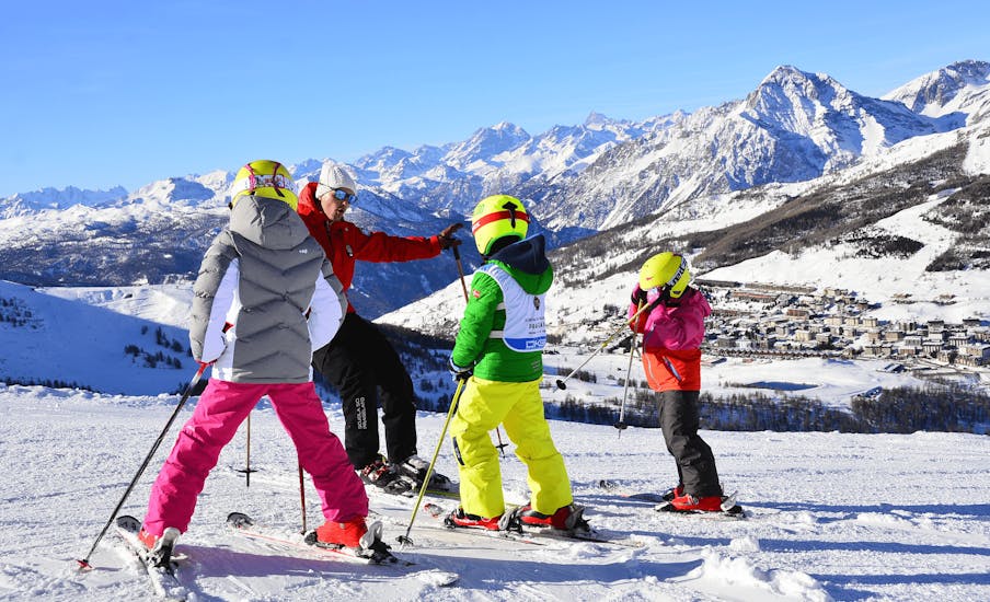 Picture of three kids and their instructor during the Kids Ski Lessons (5-15 y.) for Intermediate Skiers.