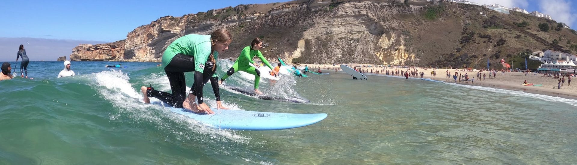 Two people riding a wave during the Private Surf Lessons (from 6 y.) in Nazaré - All Levels with Zulla Surf School Nazaré.