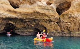 Zwei Personen, die während des Sea Kayakings von Praia dos Arrifes in Albufeira mit Surf4Fun Albufeira aus einer natürlichen Höhle kajaken.