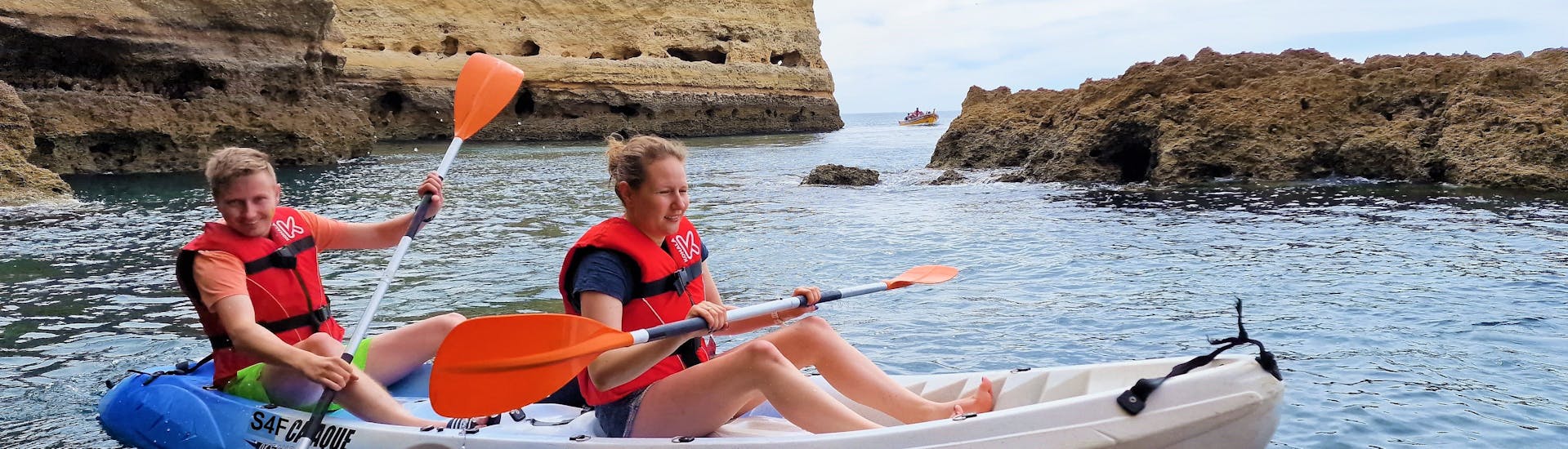 Two people coming out of a natural cave on their kayak during the Sea Kayaking to the Benagil Cave from Praia de Albandeira with Surf4Fun Albufeira.