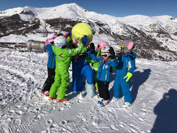I bambini festeggiano con la mascotte dopo le Lezioni di snowboard per bambini (4-8 anni) per principianti assoluti nella Scuola Sci Vialattea Sauze d'Olux
