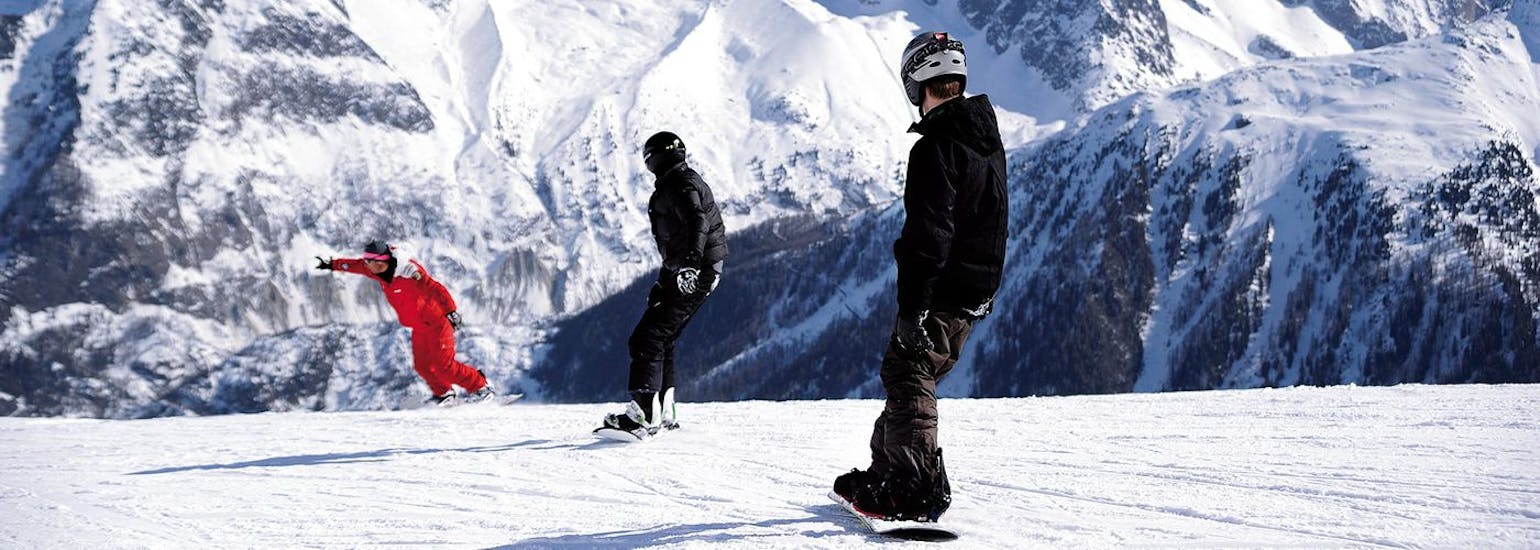 Twee snowboarders volgen hun instructeur van ESF Chamonix tijdens hun privé snowboardlessen voor kinderen en volwassenen van alle niveaus.