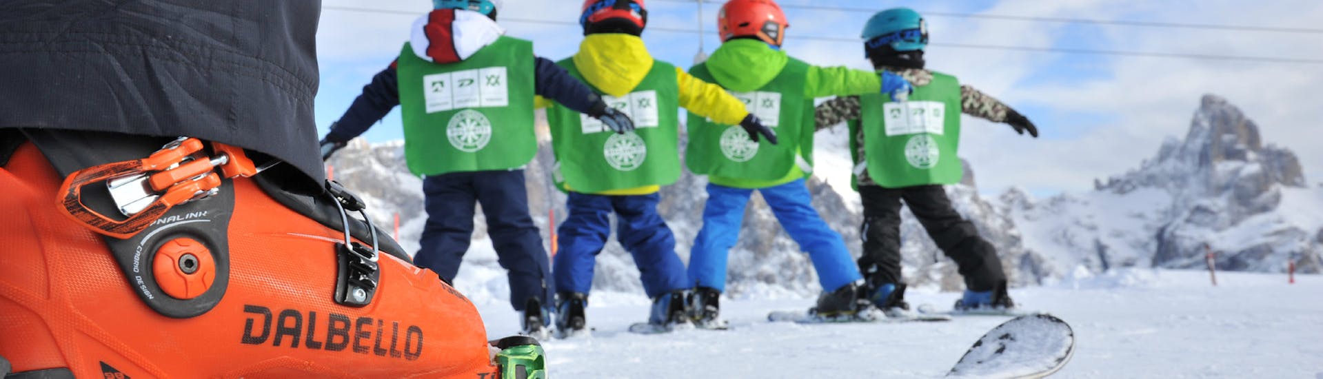 Un gruppo di bambini scia con un maestro durante le Lezioni di sci per bambini (4-5 anni) per principianti con Scuola Italiana Sci Dolomiti San Martino di Castrozza.