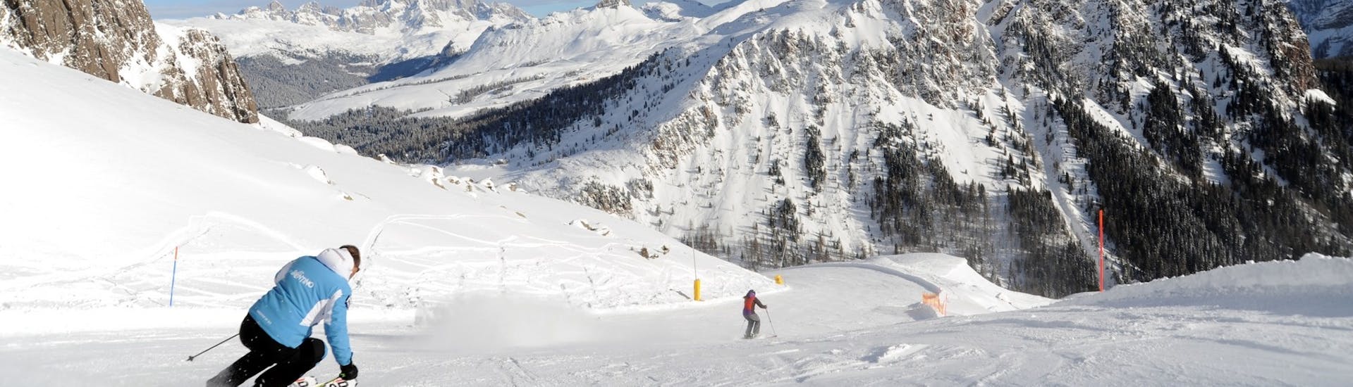 Degli sciatori sulle piste innevate delle Dolomiti durante le Lezioni di sci per adulti per tutti i livelli con Scuola Italiana Sci Dolomiti San Martino di Castrozza.