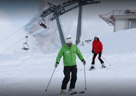 Una persona impara a fare sci con un maestro durante le Lezioni private di sci per adulti per tutti i livelli con Scuola Italiana Sci Dolomiti San Martino di Castrozza.