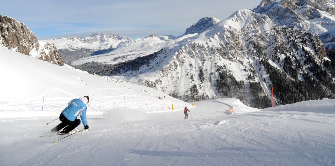 Degli sciatori sulle piste innevate delle Dolomiti durante le Lezioni private di sci per adulti per tutti i livelli con Scuola Italiana Sci Dolomiti San Martino di Castrozza.